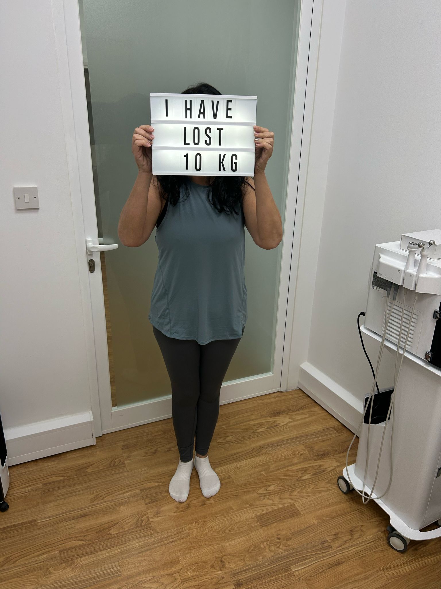 Client holding a sign reading 'I have lost 10 kg'